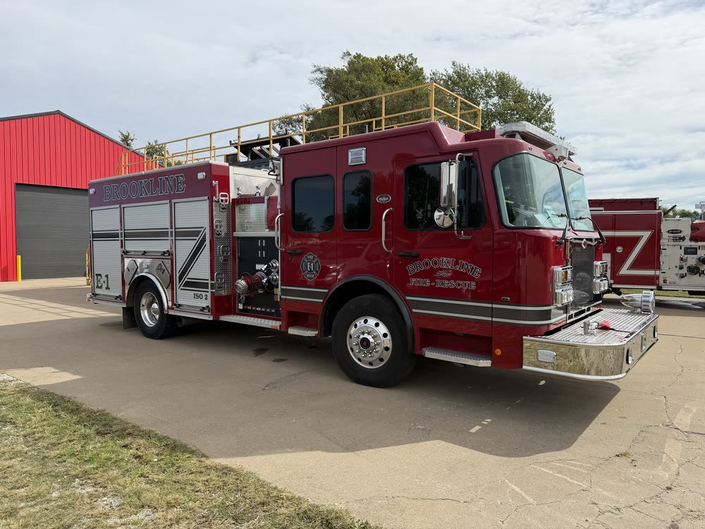 Engine 1, a red Ferrara Spartan pumper, parked on the apron outside the station